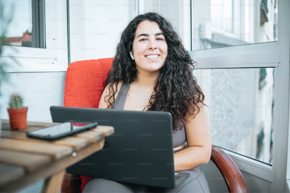 a woman sitting in a chair with a laptop