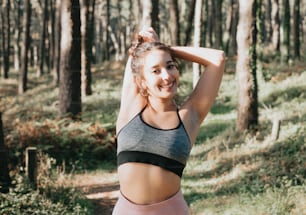 a woman in a black and grey sports bra top in the woods