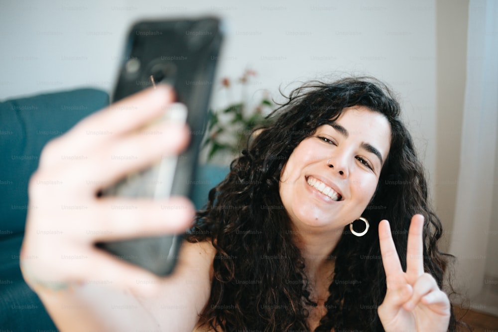 a woman sitting on a couch holding a cell phone