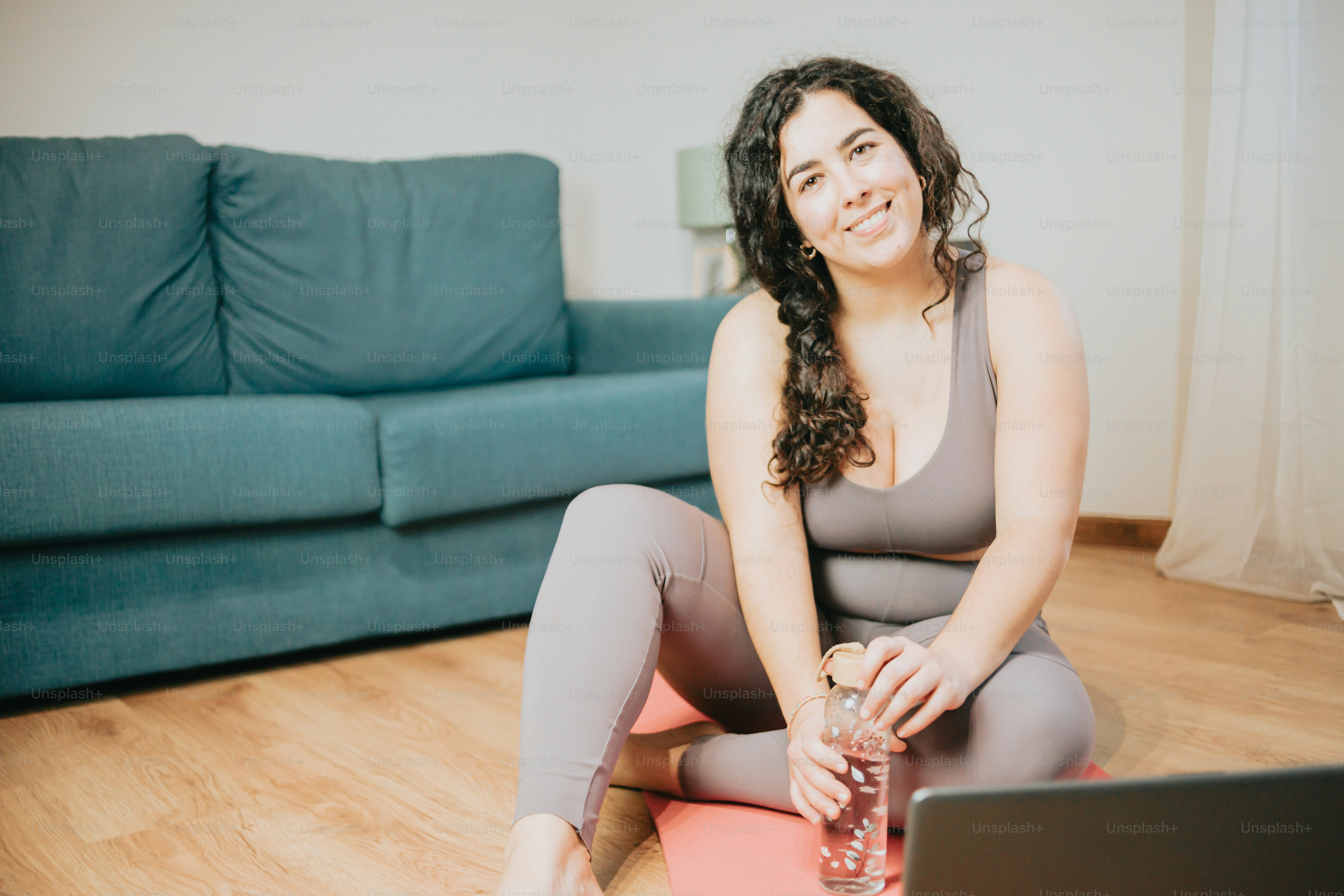 uma mulher sentada no chão com um laptop