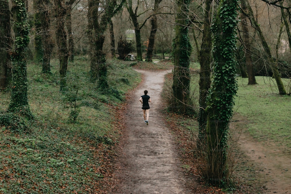 a person running down a path in the woods
