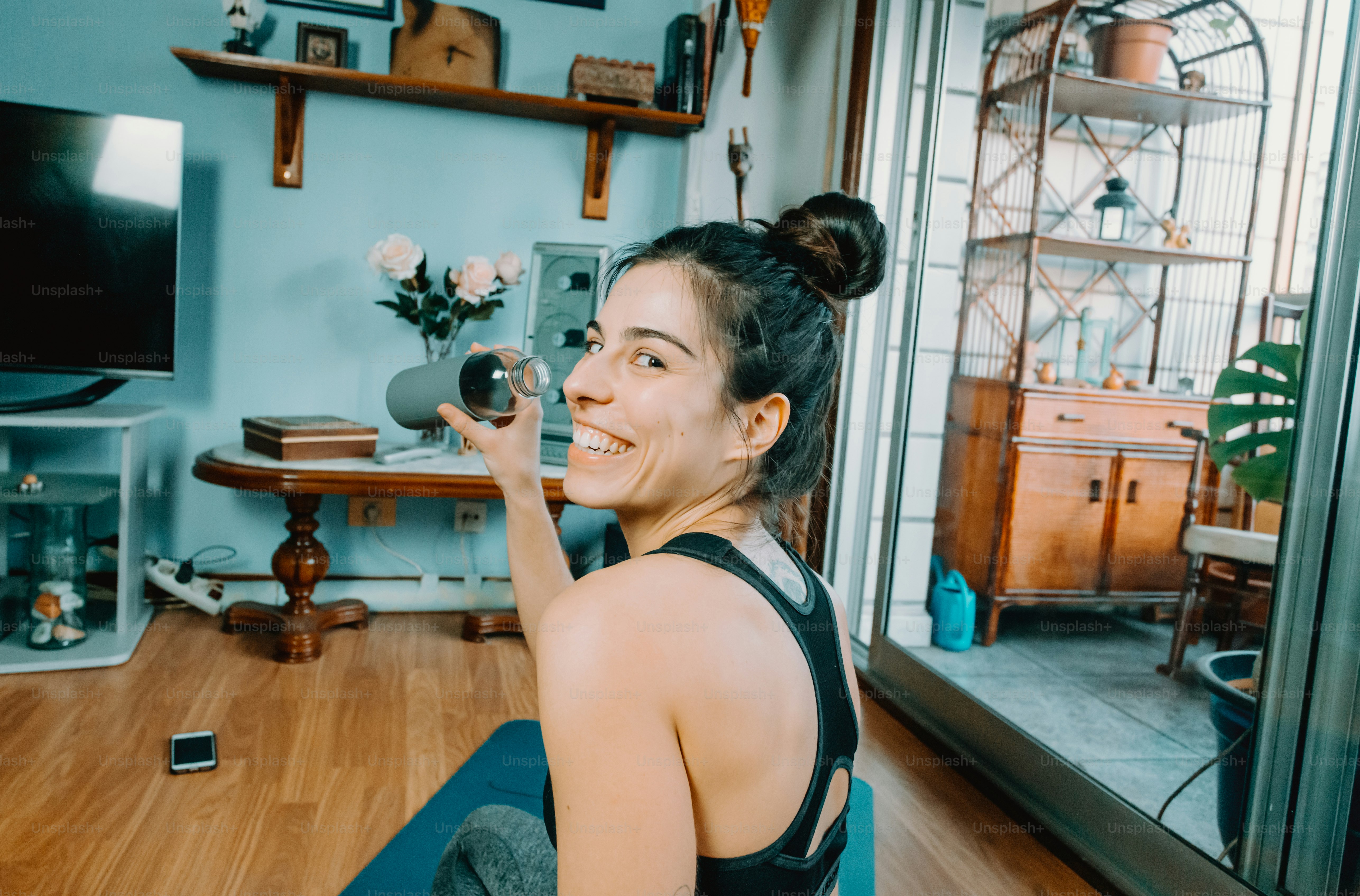 a woman sitting on a yoga mat in a living room