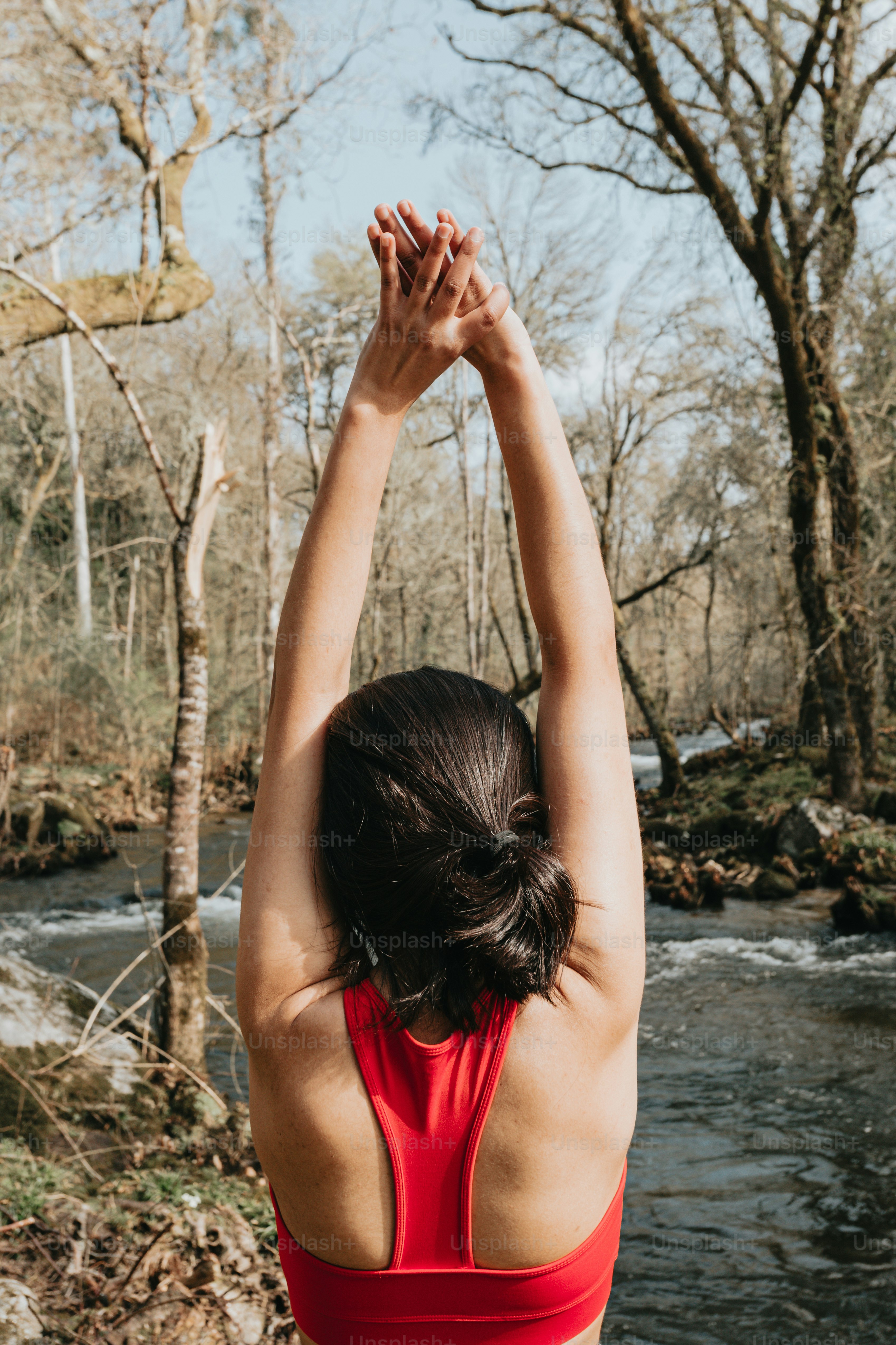 a woman in a red swimsuit standing in front of a river