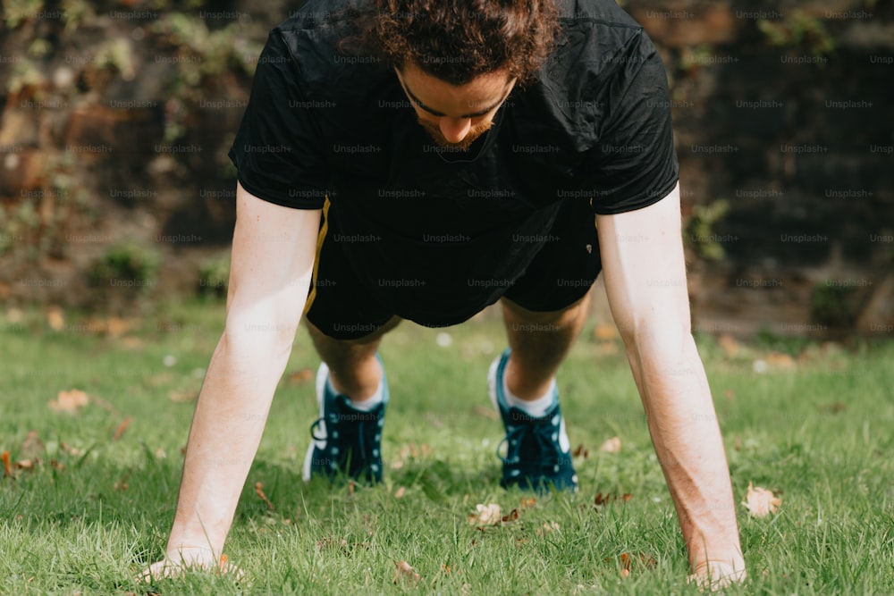 a man is doing push ups in the grass