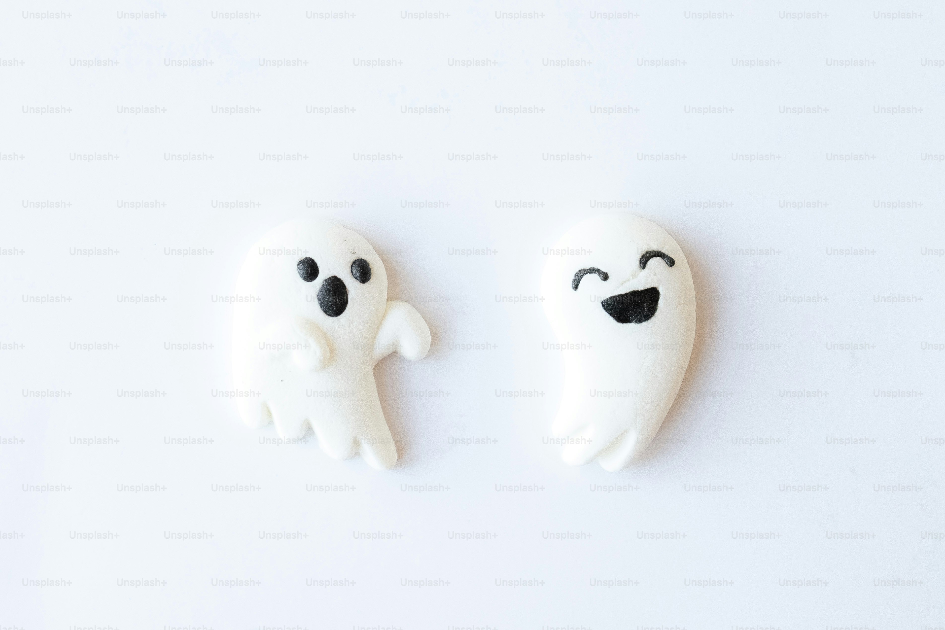a couple of white ghost cookies sitting on top of a table