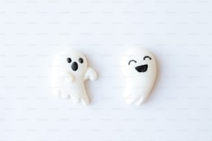 a couple of white ghost cookies sitting on top of a table