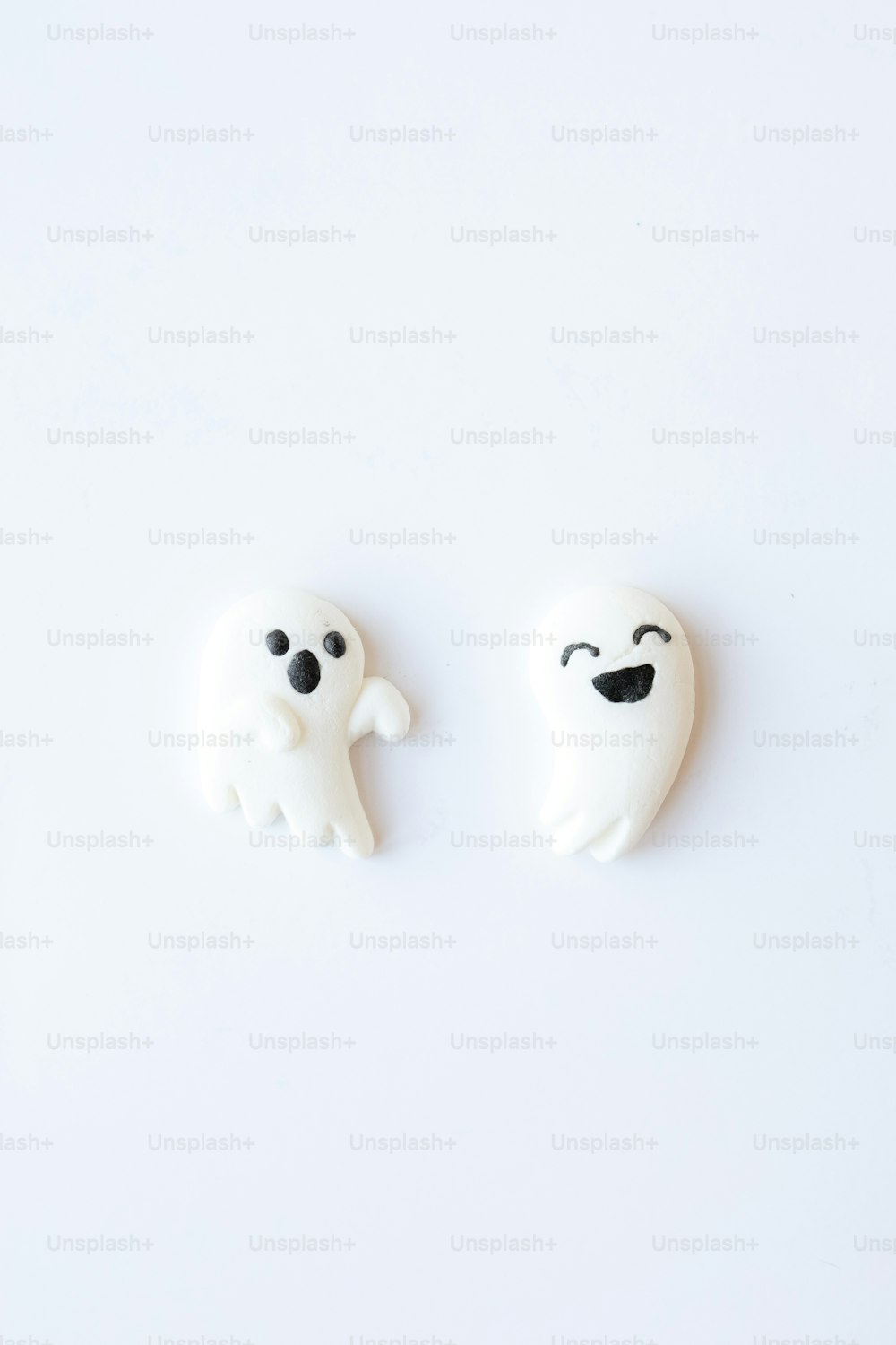 um par de ímãs fantasmas brancos sentados em cima de uma mesa