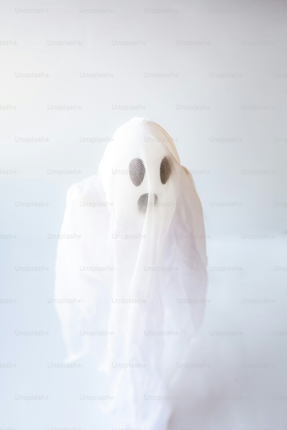 a white ghost with a black nose and eyes