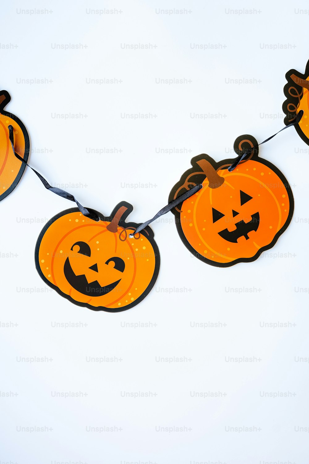 eine Reihe von Halloween-Kürbissen, die an einer Leine hängen