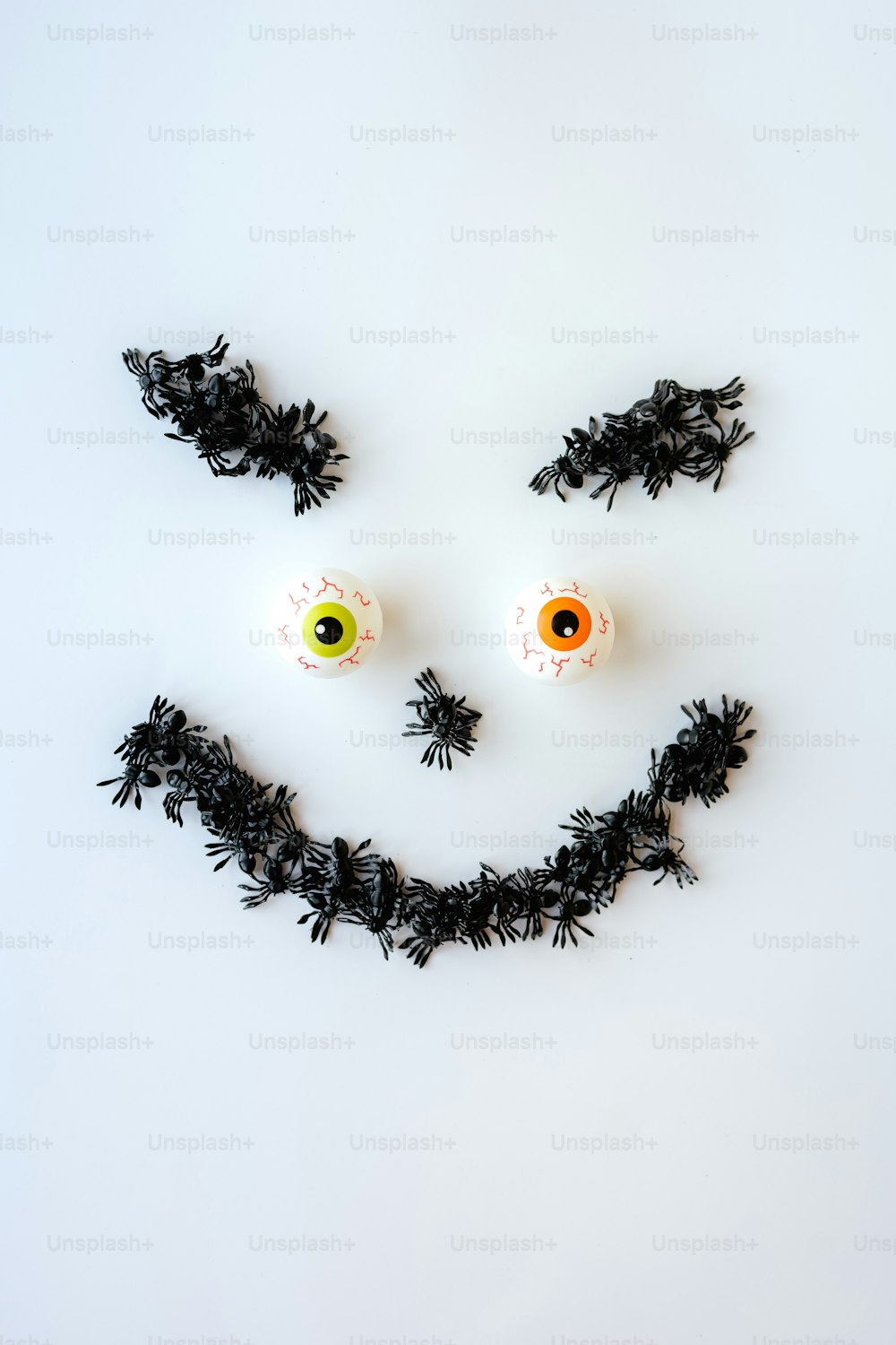 a smiley face made out of black leaves