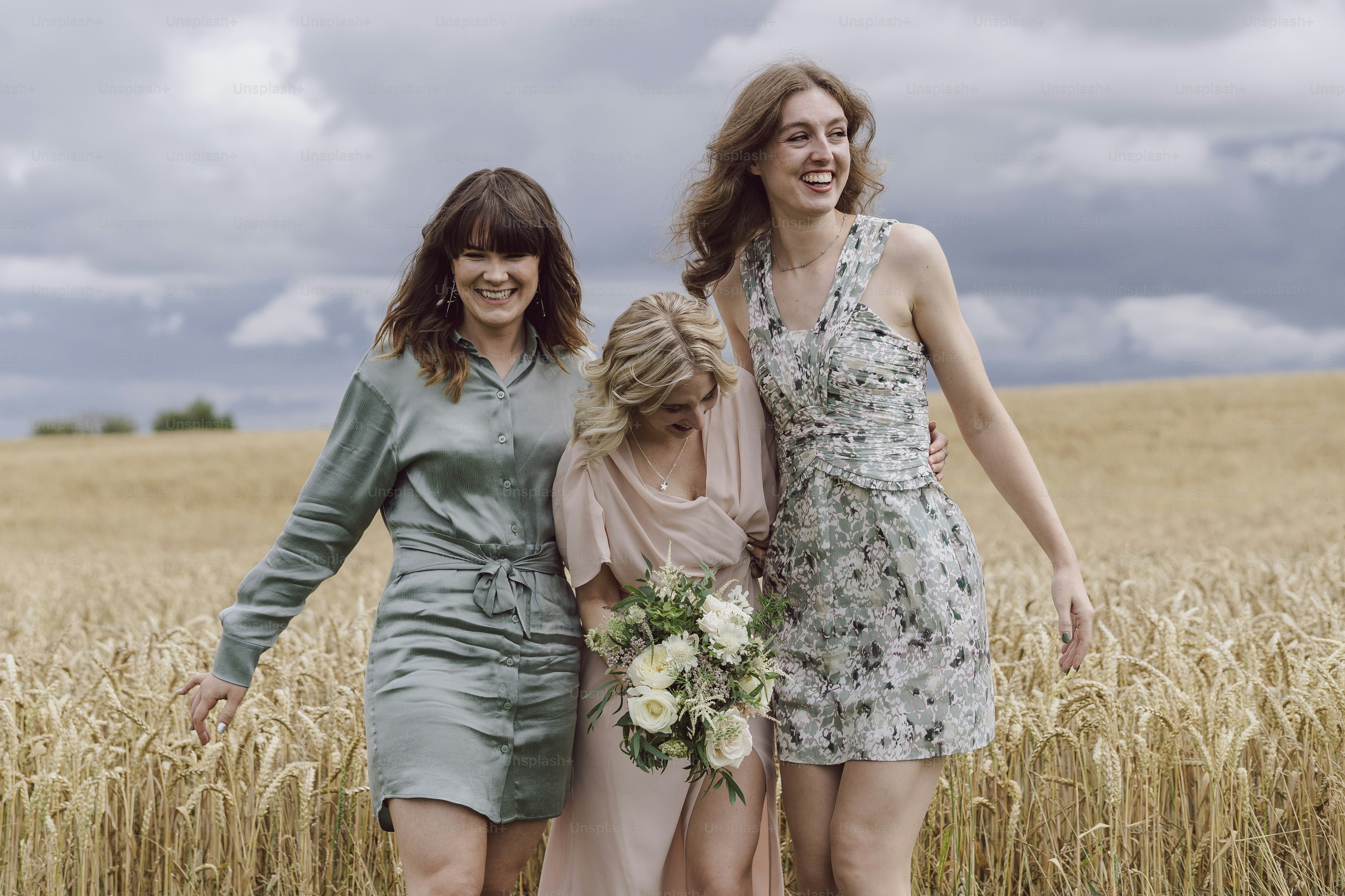 A group of women standing next to each other in a field photo – Wedding ...