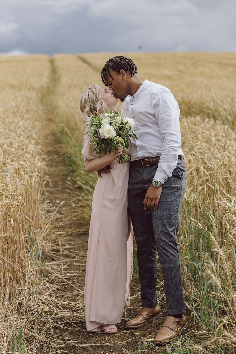 a man and a woman standing in a wheat field