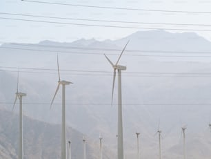 a row of wind turbines in a mountainous area