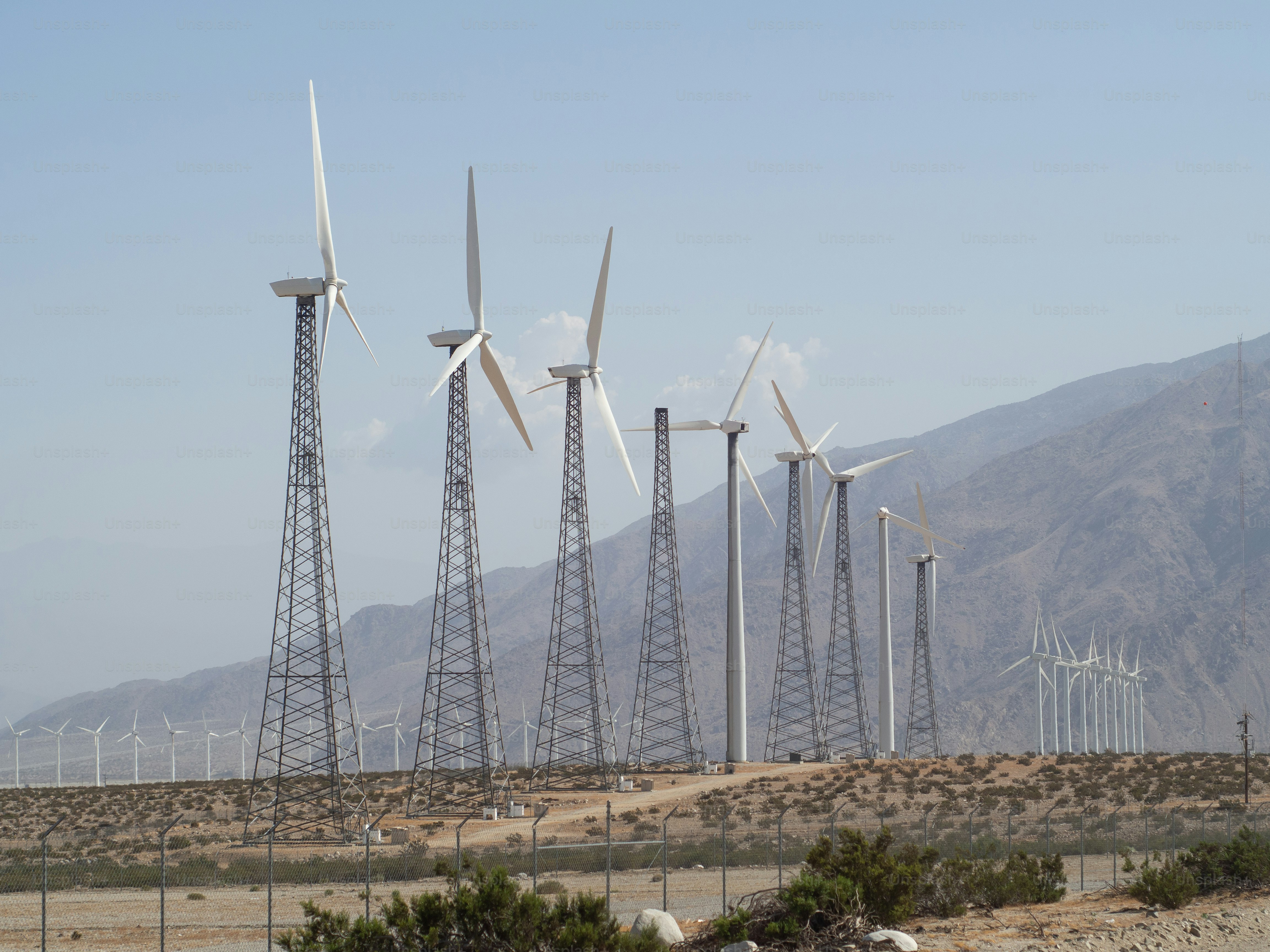 a bunch of windmills that are standing in the dirt