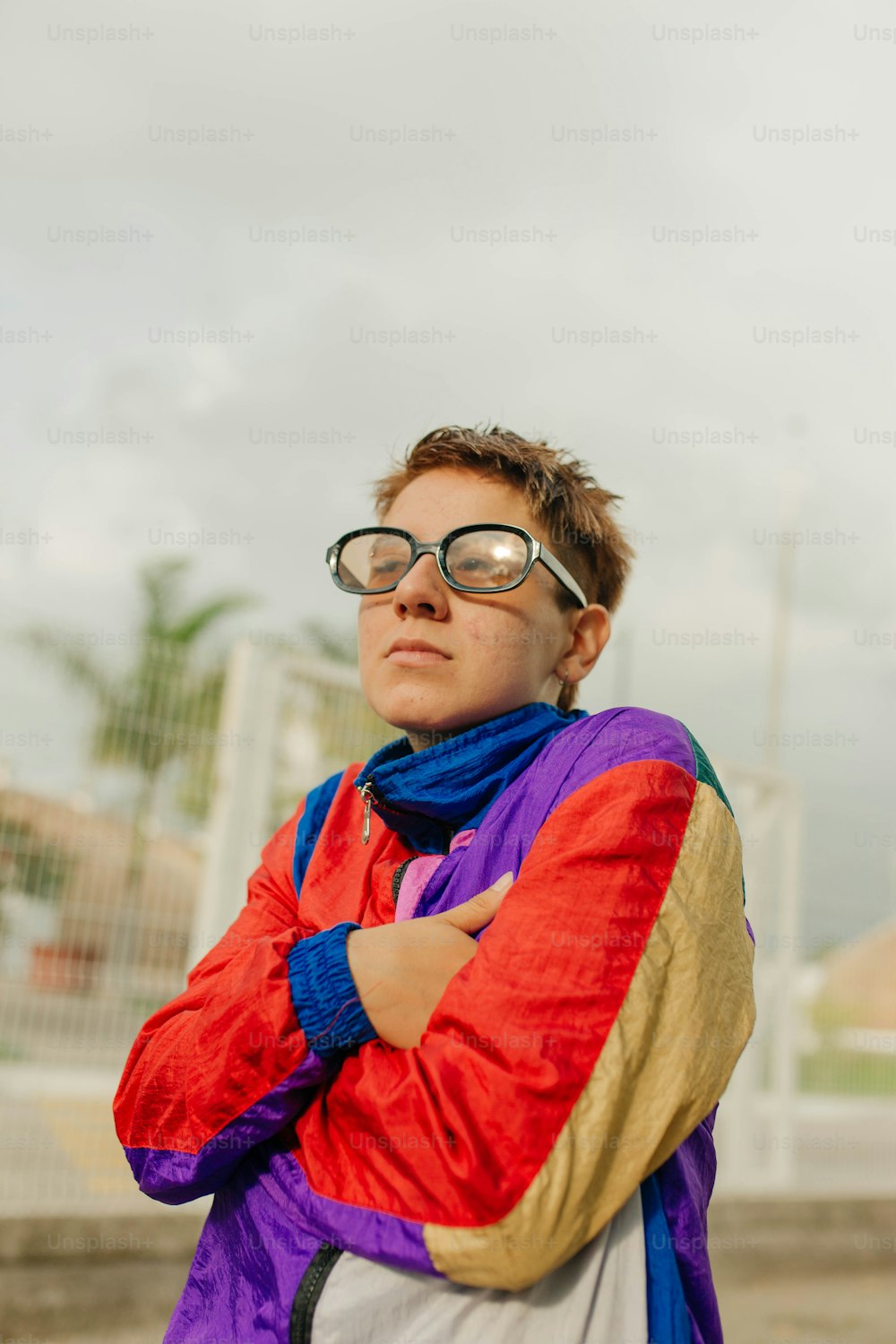 a woman with her arms crossed wearing glasses