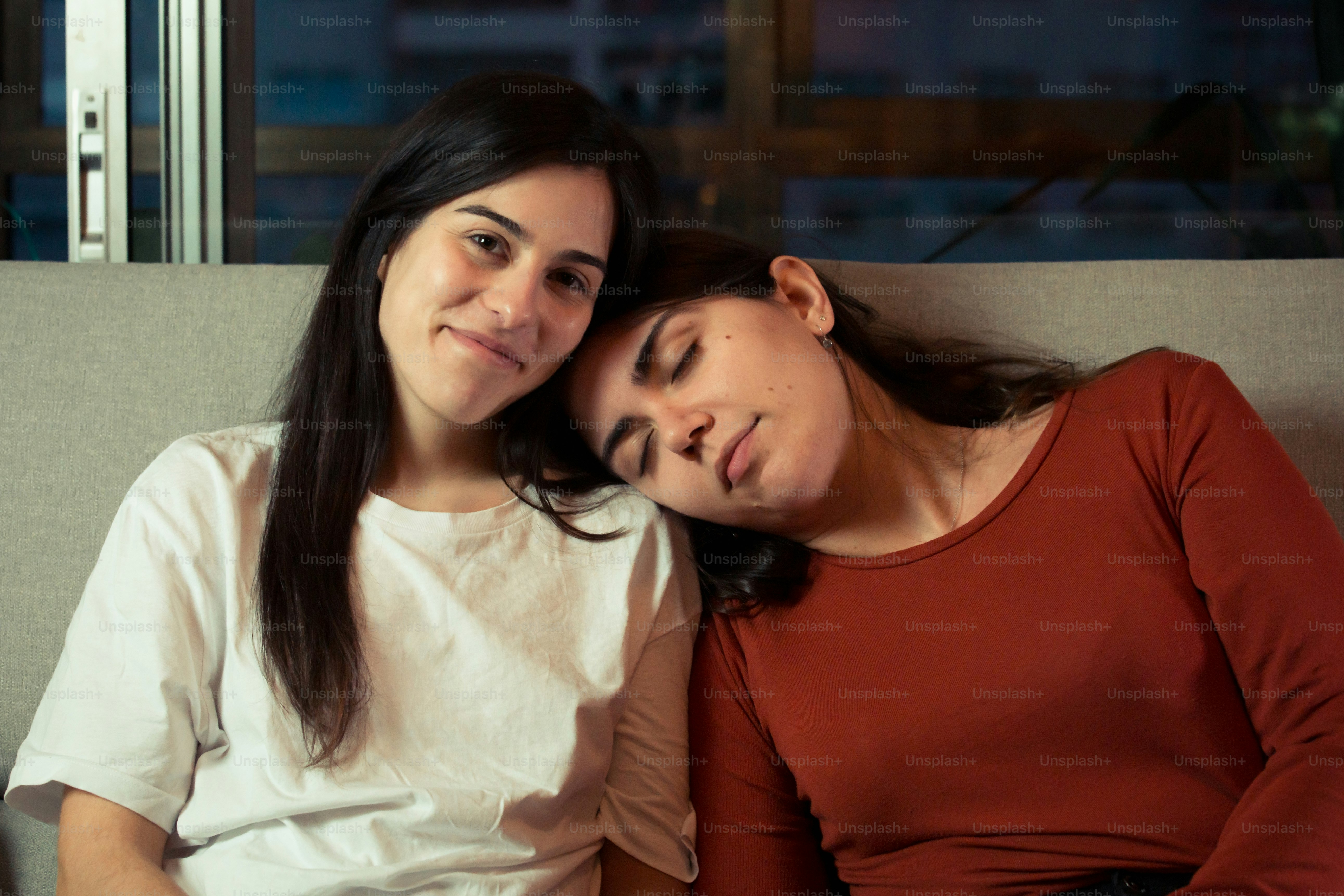 a couple of women sitting next to each other on a couch