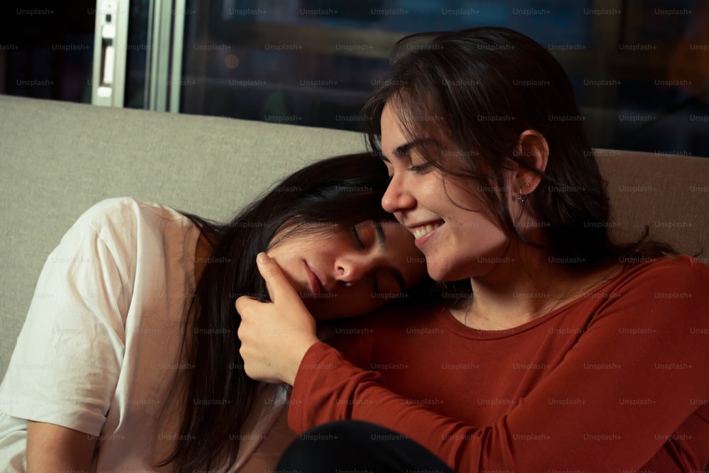 a couple of women sitting next to each other on a couch