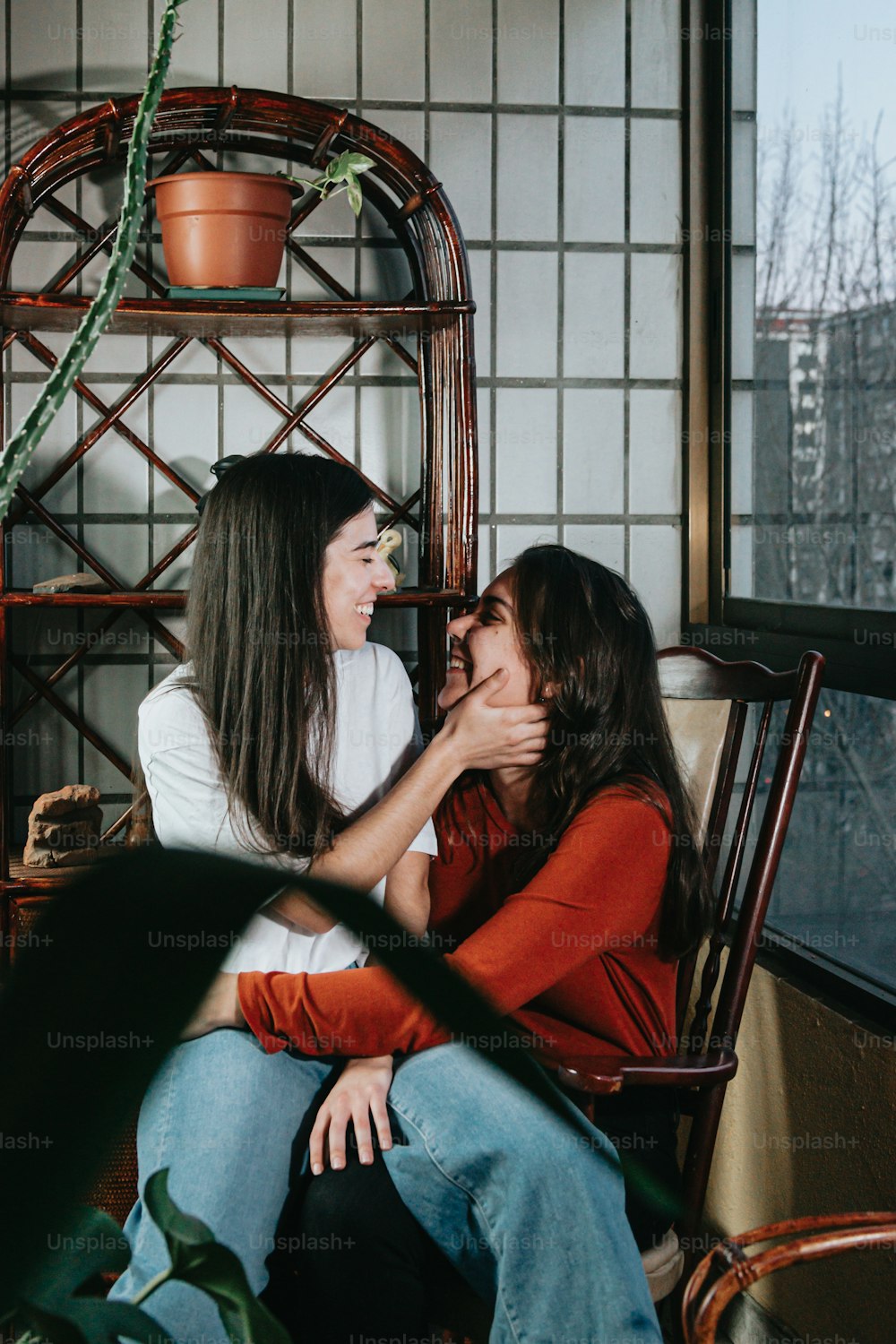 two women sitting on a chair with their arms around each other