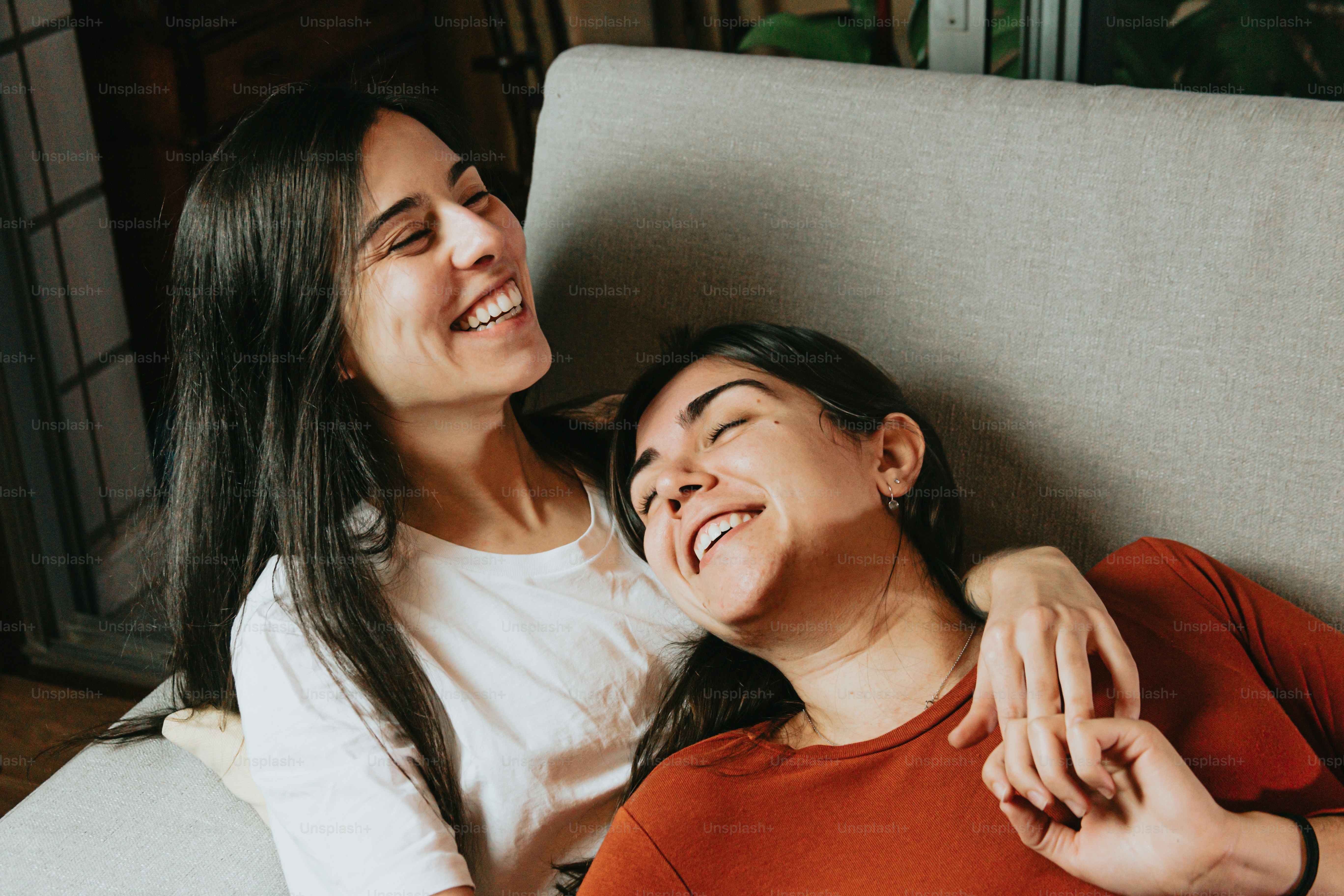 a couple of women sitting next to each other on a couch