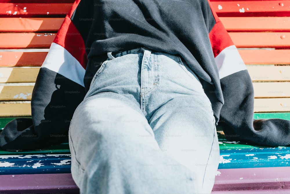 a person sitting on a bench with their feet on the ground