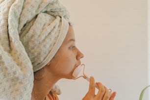 a woman with a towel wrapped around her head eating something
