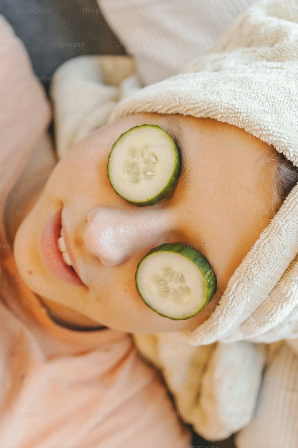 a woman with cucumber slices on her eyes