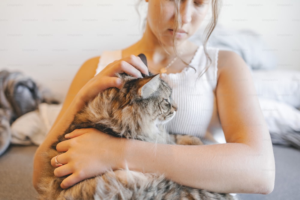 Una donna tiene un gatto tra le braccia