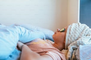 un jeune enfant dormant sur un lit avec une couverture