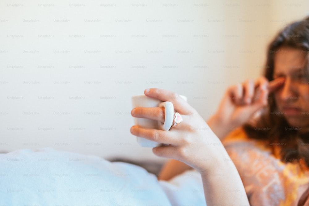 a woman holding a video game controller in her hand