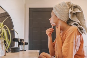 a woman with a towel on her head sitting on a counter