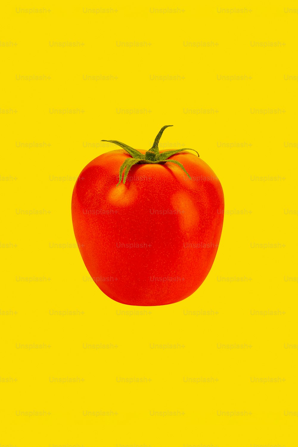 um tomate vermelho em um fundo amarelo