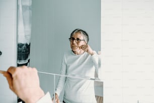 a woman is looking at herself in the mirror