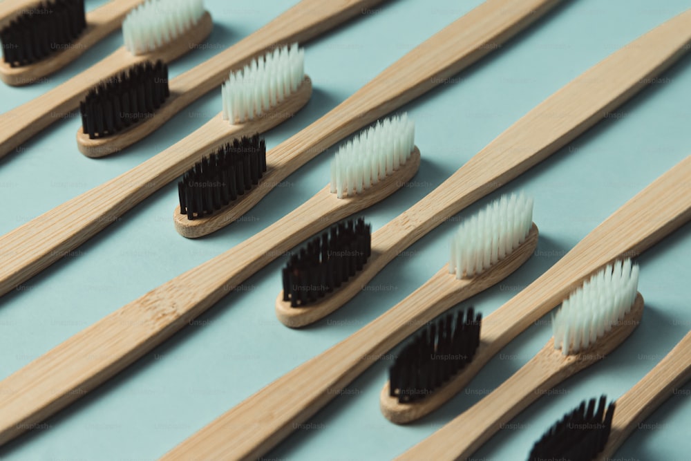 a row of wooden toothbrushes lined up on a blue surface