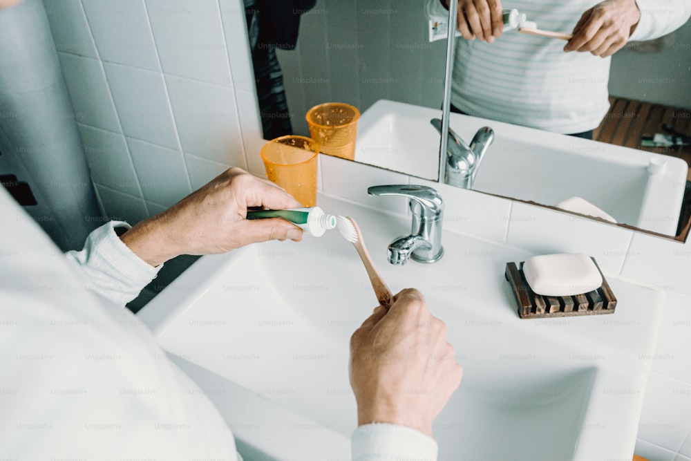 a person brushing their teeth in front of a mirror