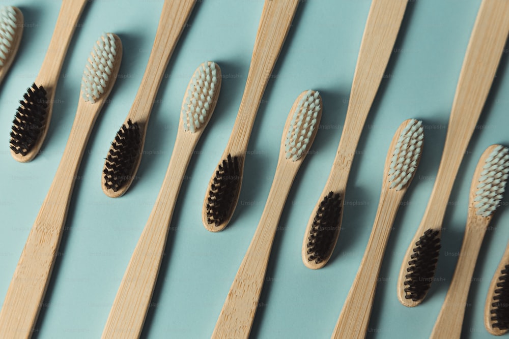 a row of wooden toothbrushes lined up on a blue surface