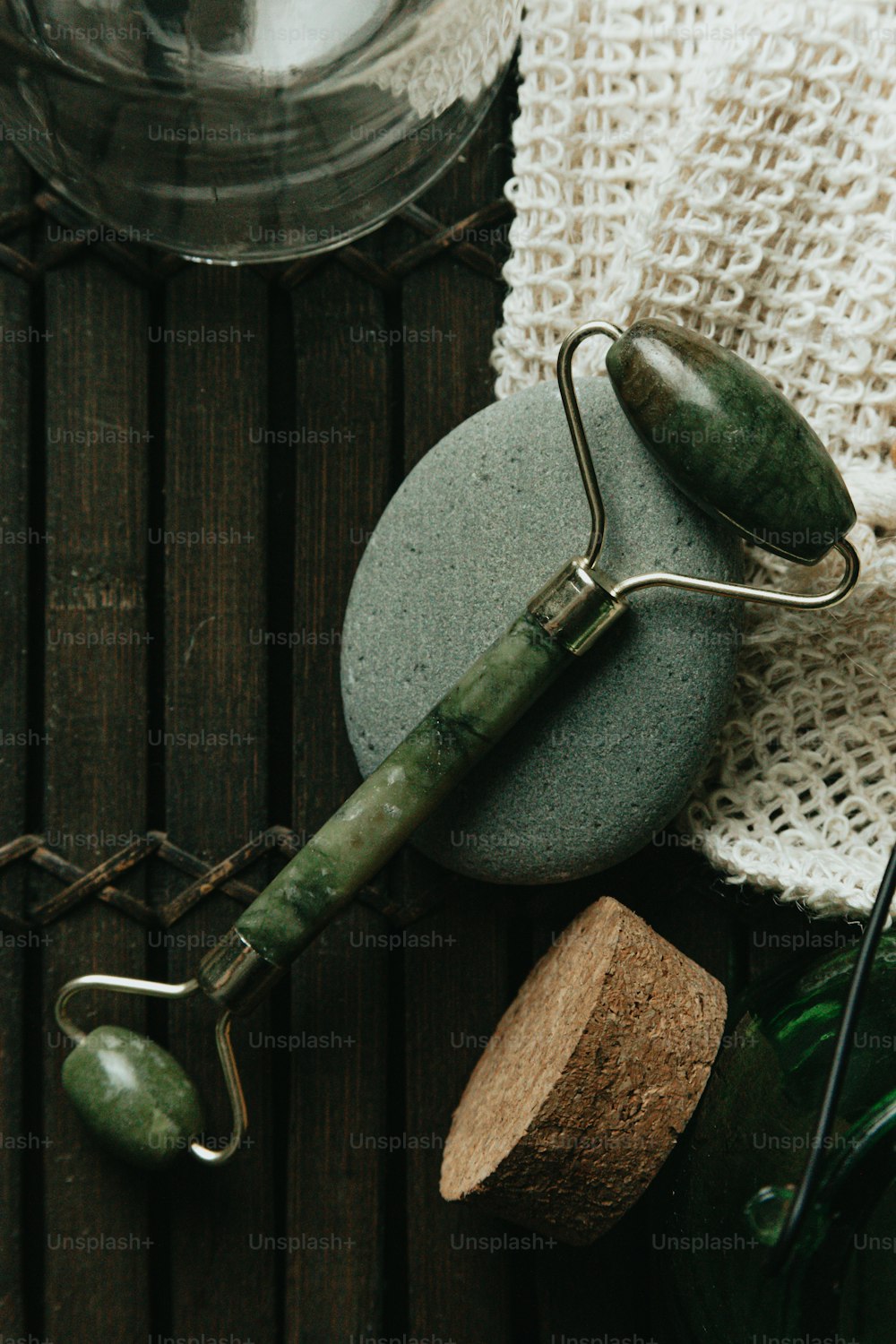 a green stone with a green handle and a metal hook