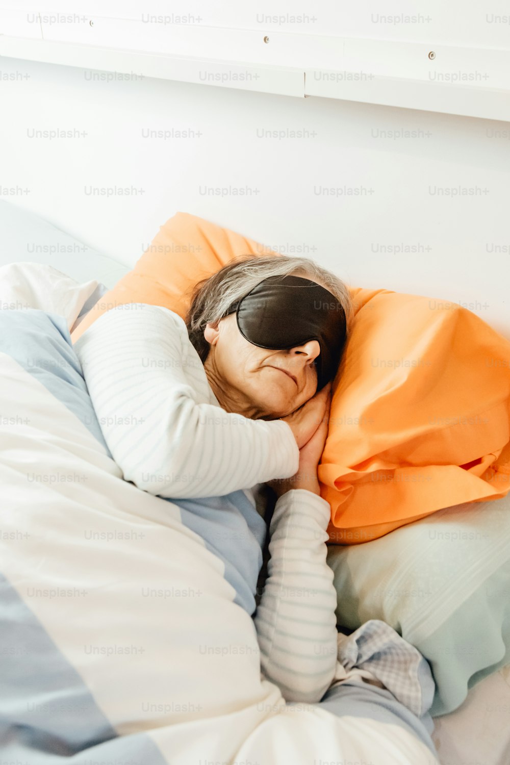 a woman laying in bed with a sleeping mask on