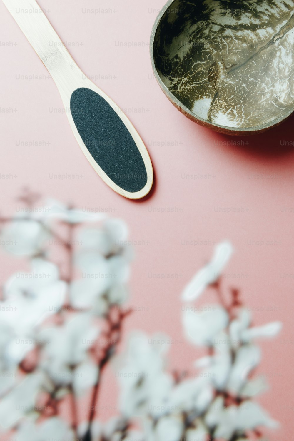 a spoon and spoon rest on a pink surface