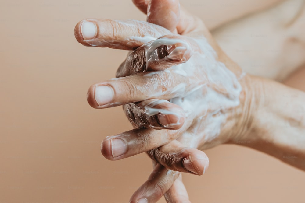 uma pessoa está lavando as mãos com sabão