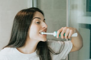 a woman brushing her teeth in the bathroom