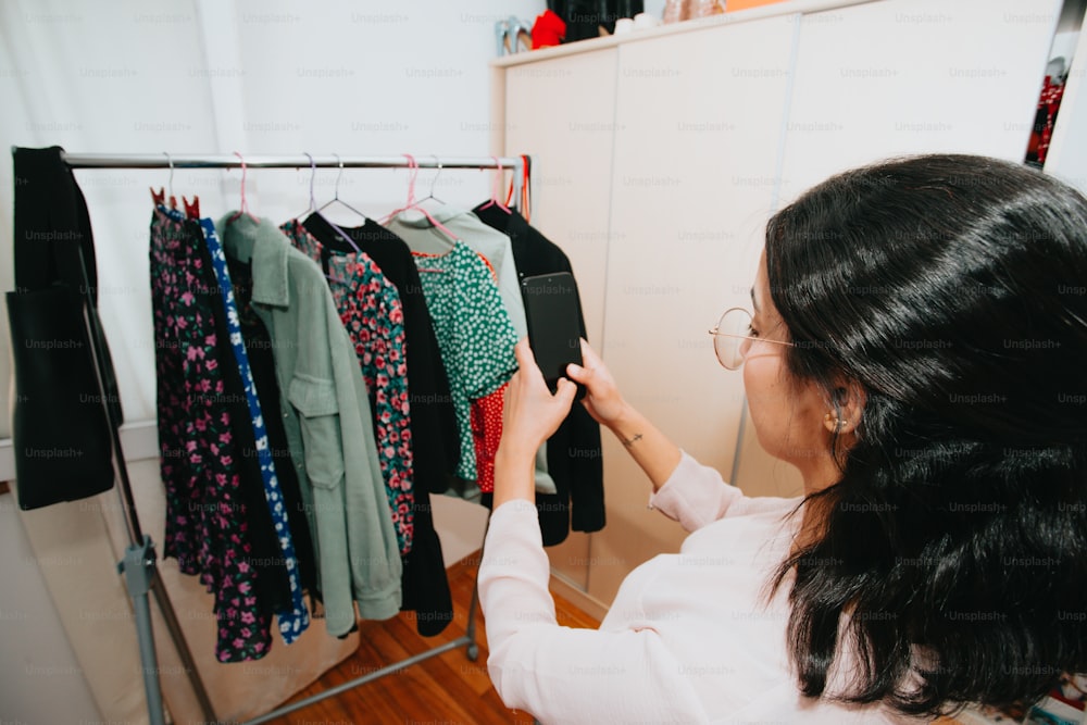 a woman looking at a rack of clothes