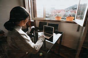 a woman standing in front of a laptop computer