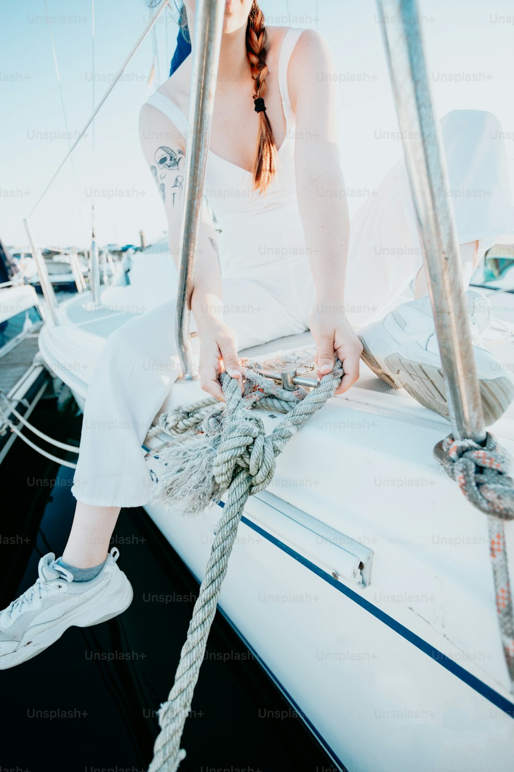 una donna seduta sulla cima di una barca a vela