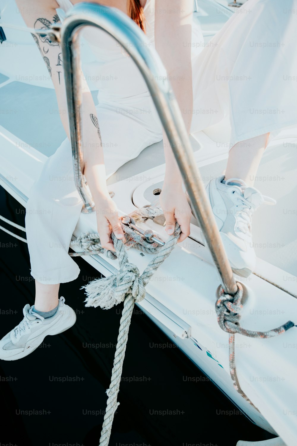 uma mulher está sentada em um barco com uma corda