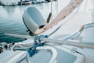 a person with tattoos on their arm standing on a boat
