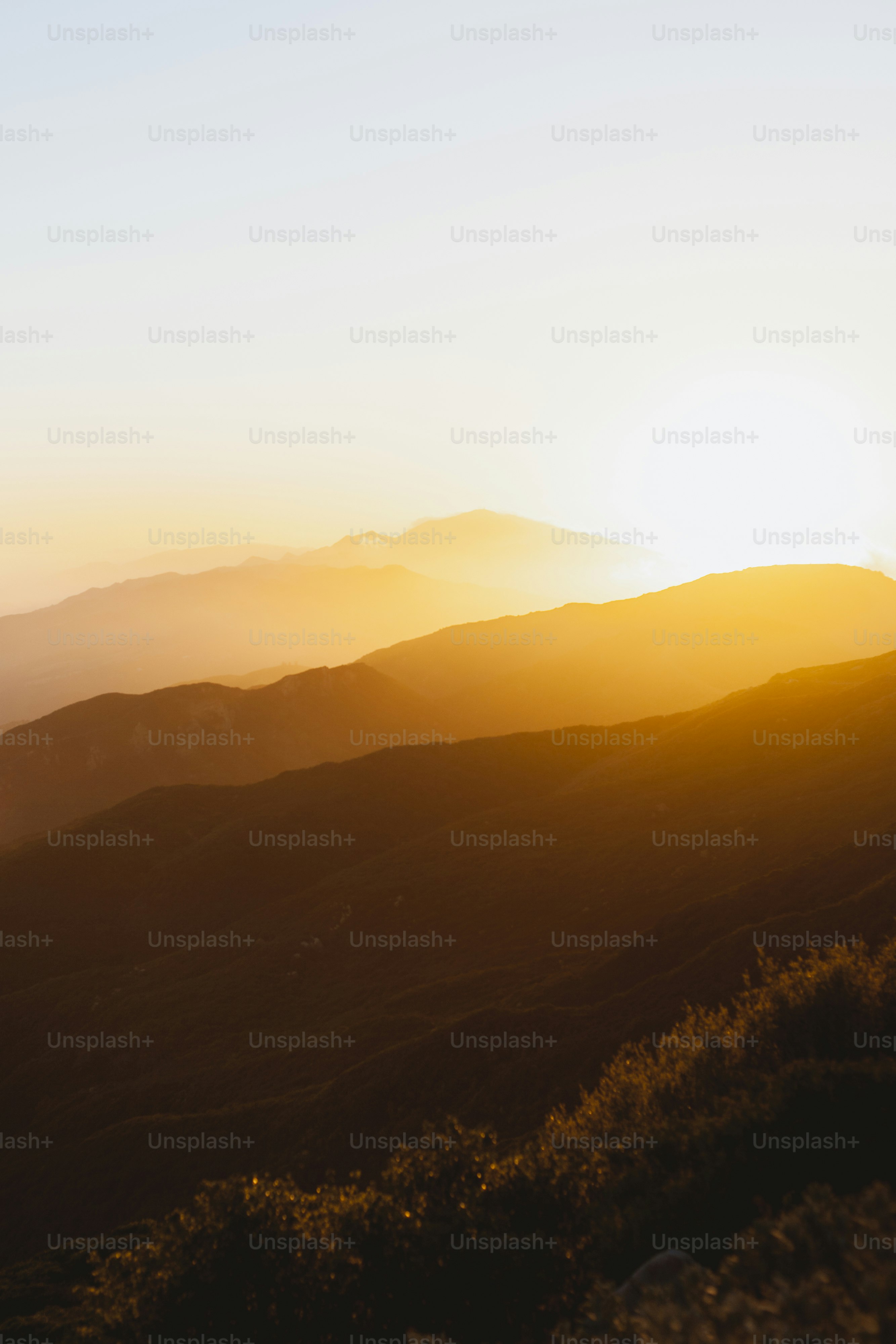 the sun is setting over a mountain range