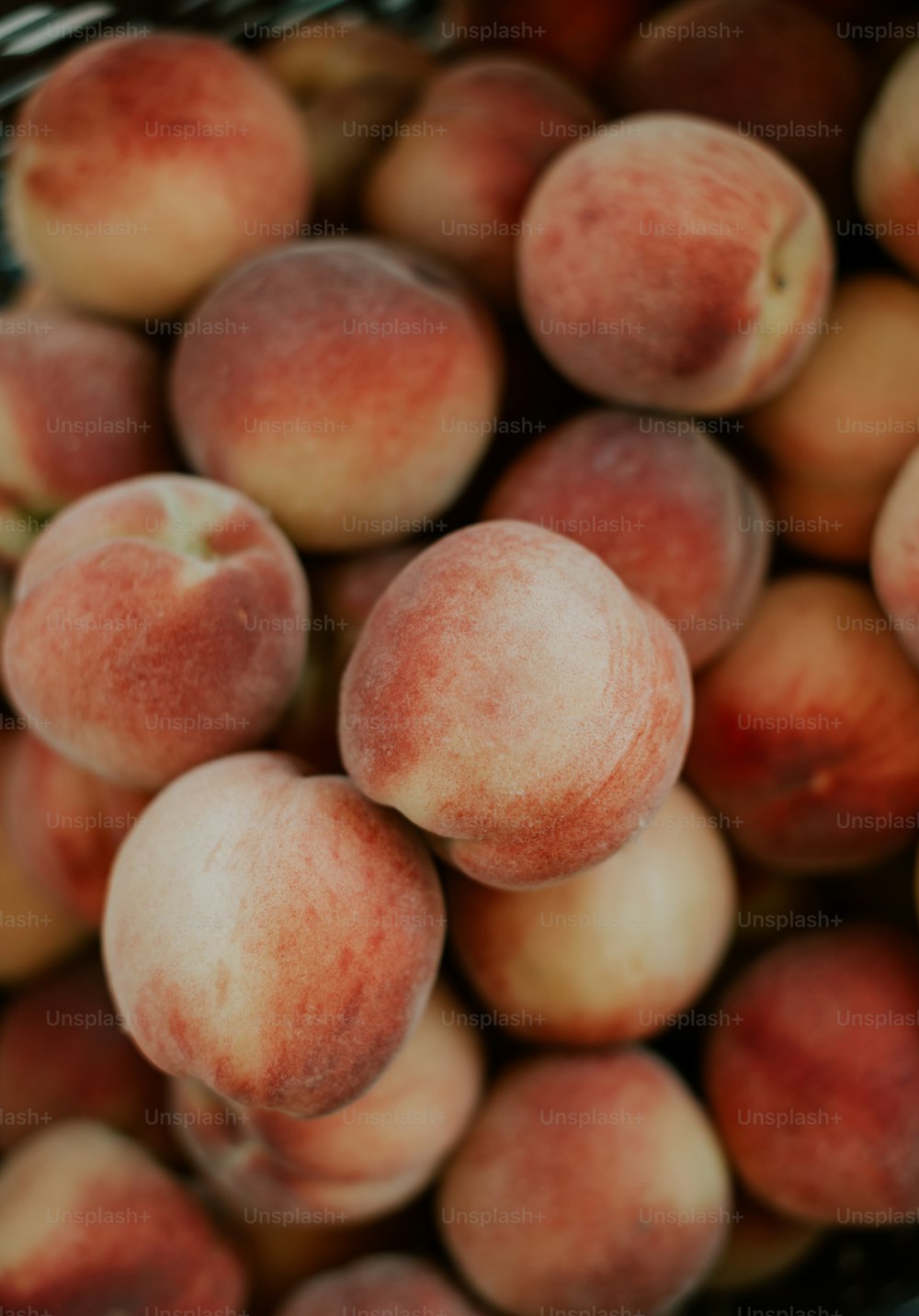 a close up of a basket of peaches
