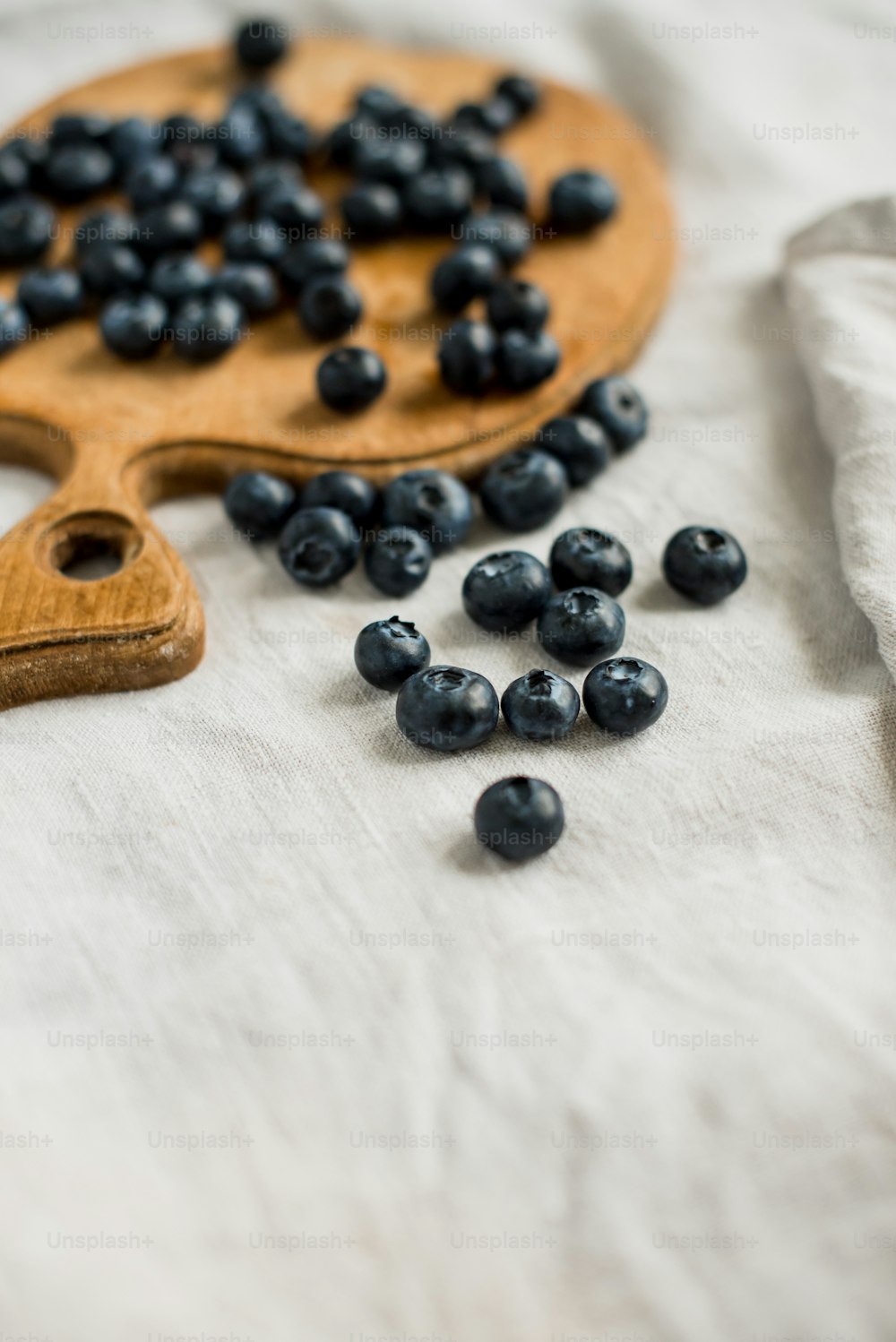 a wooden cutting board with blueberries on it