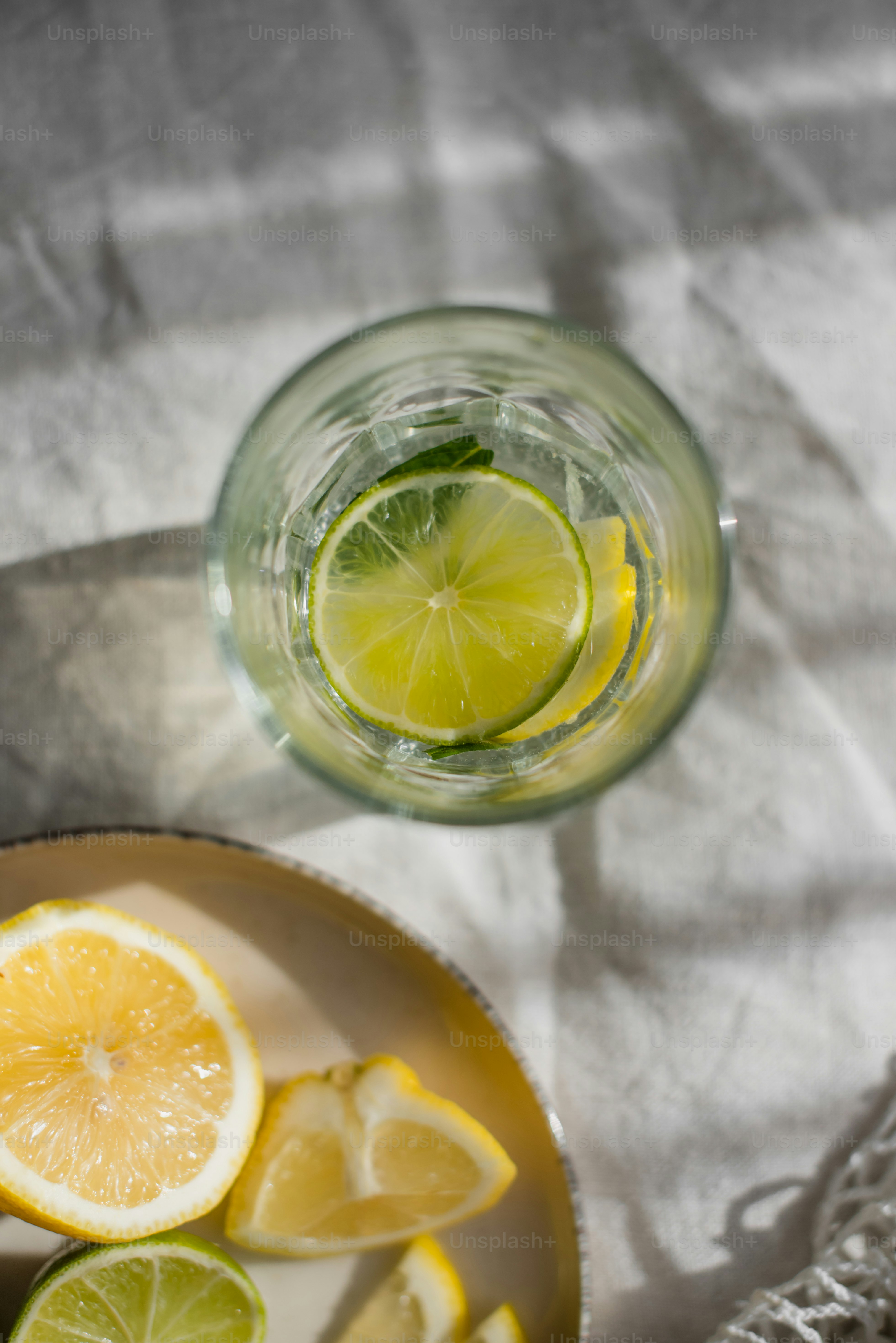 una ciotola di limoni e un bicchiere d'acqua