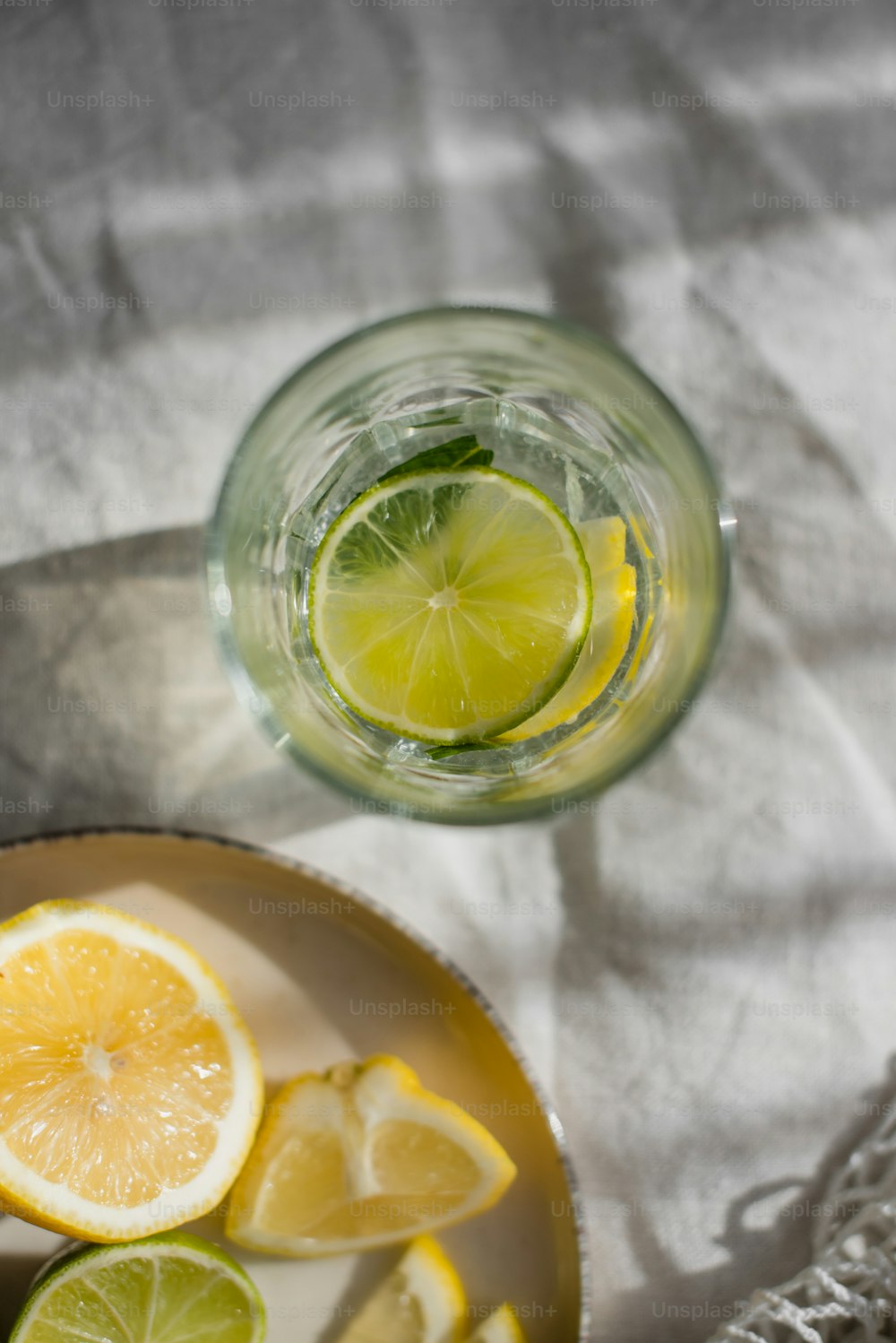 a bowl of lemons and a glass of water